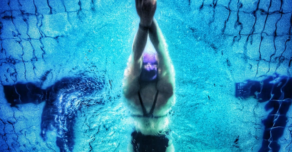 Captivating underwater shot of a swimmer in a pool with clear blue water.